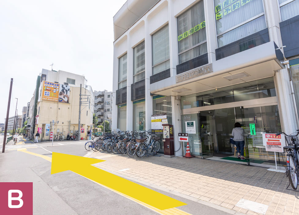 三井住友銀行の前。黄色い矢印が、銀行に沿って進む向きを示しています。